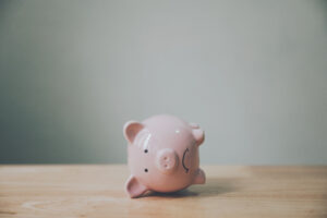 Piggy bank laying on it's side with a sad face. Economy, inflation, markets, finance